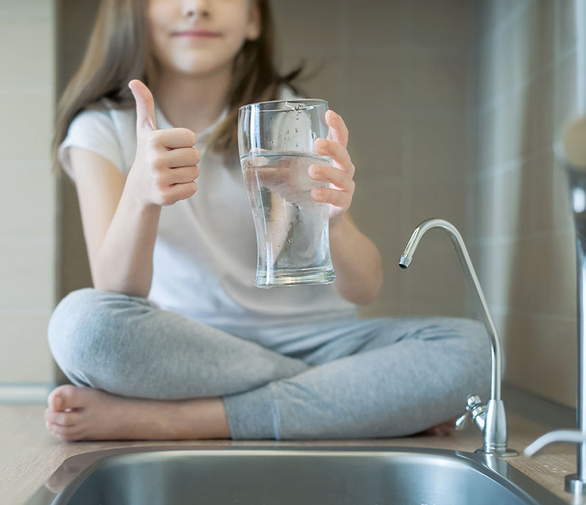 Little child drinking from water tap