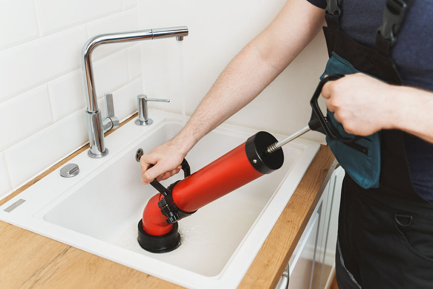 A Person Cleaning the Sink Drain