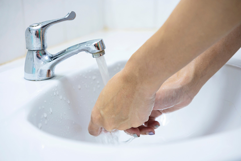 Woman washing hands in sink