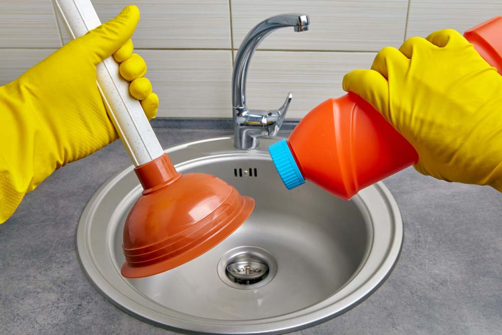 person pouring chemical cleaners down the drain