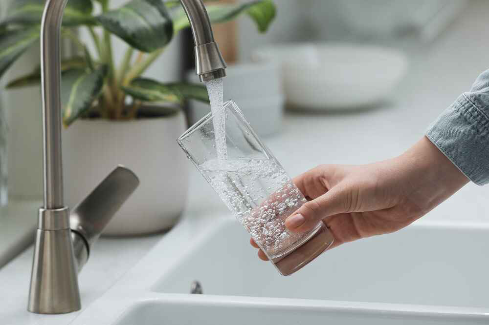 woman filling glass with water