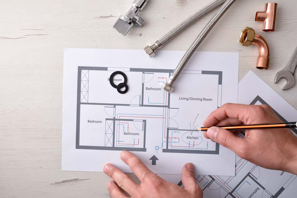 plumber looking at plans on a table