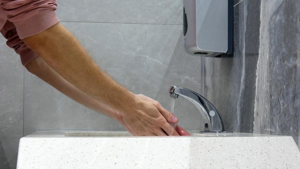 person using touchless kitchen faucet