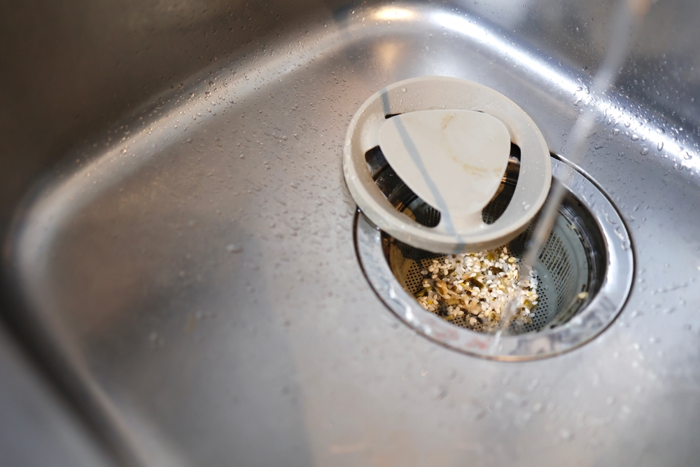 Food waste accumulated in the drain of the kitchen sink.