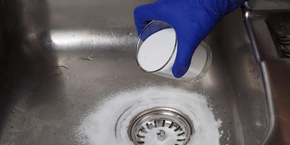 person pouring baking soda down the drain